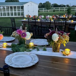 Outdoor table setting with flowers and candles for bubbles and blooms